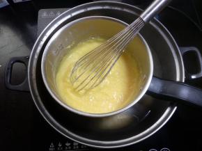 16.这期间要用手抽不停匀速搅拌，锅底每个角落都要搅拌到。用中小火，因为温度有些高，小心蒸汽烫伤，没有把手的容器用湿水布包住或带手套，扶紧容器边沿，我用的是带把的奶锅会比较方便。打蛋器或刮刀要不停的搅拌，以免结块糊底。 