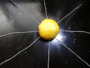 29.在线交叉点上，放上包好的奶黄南瓜面团，面团收口朝底面。 