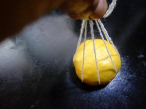 30.用手一根根提起每一条线。 
提起所有线打一个结，面团和打结之间要预留一点距离。棉线绑面团时略松一些，绑好后用手整理一下线之间距离。因为在二次发酵和烘培时还会膨胀变大的。 