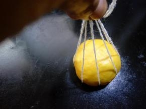 30.用手一根根提起每一条线。 
提起所有线打一个结，面团和打结之间要预留一点距离。棉线绑面团时略松一些，绑好后用手整理一下线之间距离。因为在二次发酵和烘培时还会膨胀变大的。 