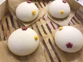 取黄色面团，分成0.5克的小面团，揉圆后用刮板在中间按一下，沾少许水放在白色面团合适位置当小鸡嘴巴