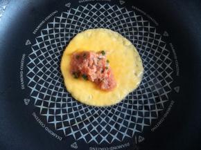 蛋液开始凝固的时候放上适量的猪肉馅