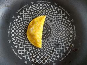 用锅铲把右边的蛋饼往左盖住肉馅