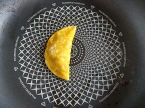 用锅铲把右边的蛋饼往左盖住肉馅