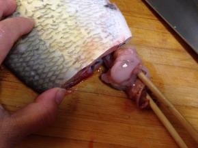 用一双筷子夹住鱼内脏旋转向外拉就可以取出内脏，然后洗净
