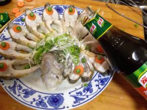
鱼出锅后，倒掉盘子中蒸出的水，摆上泡好的葱丝，用青豆做装饰倒上蒸鱼豉油