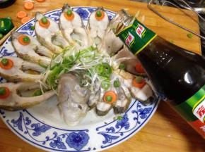 
鱼出锅后，倒掉盘子中蒸出的水，摆上泡好的葱丝，用青豆做装饰倒上蒸鱼豉油