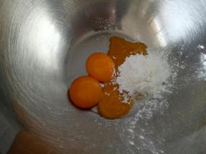 将玉米淀粉和糖粉放入蛋黄中，滴几滴柠檬汁