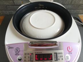 装南瓜的碗放入电饭煲里，盖上一个碗，防止蒸的过程中南瓜进水