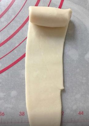 把面团从接口处擀成牛舌状，再一次卷起来