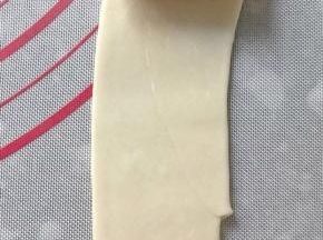把面团从接口处擀成牛舌状，再一次卷起来