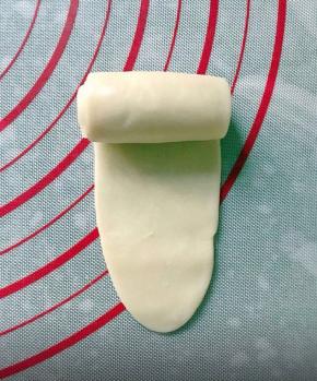 把面团擀成牛舌状，卷起来，继续静置10分钟