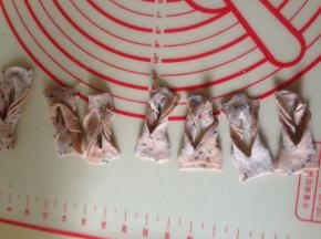 把一头从中间的割口套过来 完成一个  逐个操作好  锅里烧热油  3~4成热  逐个下油锅 炸至浮起  翻个