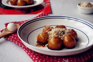 将糯米团子捞起来放在碟子中，淋少量的红糖浆，表面洒上备好的花生芝麻碎