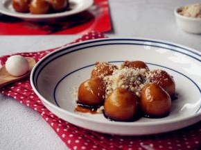 将糯米团子捞起来放在碟子中，淋少量的红糖浆，表面洒上备好的花生芝麻碎