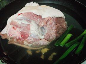 洗净猪肘子后放入锅中冷水没过肘子，放入适量的姜片，葱段和4勺料酒，开大火煮沸