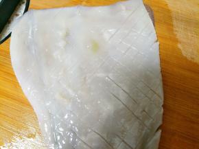 在鱿鱼没有皮的那面斜着切菱形，不要切断，做这个菜谱的时候，老公切反了，所以卷不起来