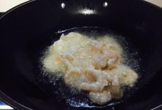 大火起锅，锅热，放入500g左右的油，当油温5～6成热时，放入虾仁。