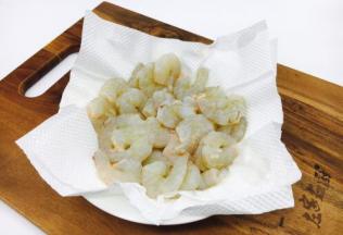 用餐巾纸吸干虾仁的水份。