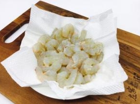 用餐巾纸吸干虾仁的水份。