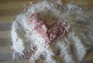 泡好糯米捞出来，擀成半颗粒状，腌制好的羊排裹满碎米