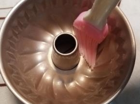 计算好时间170度预热烤箱，同时用准备好的黄油在模具表面薄薄的刷上一层。