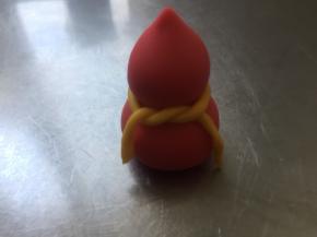 红色面团的葫芦。两个小圆球，下面的15克搓成圆球形状，上面的6克先搓成圆球，再把一段搓出一份尖，坐在大圆球上面，中间用牛奶粘一下，再用黄色面团搓成细细的长条，系一下，OK