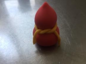 红色面团的葫芦。两个小圆球，下面的15克搓成圆球形状，上面的6克先搓成圆球，再把一段搓出一份尖，坐在大圆球上面，中间用牛奶粘一下，再用黄色面团搓成细细的长条，系一下，OK