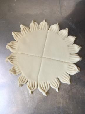 擀成饼。用叉子转圈压出花纹，在用刀沿着叉子印记切开，用手捏一下，漂亮的底盘做好啦