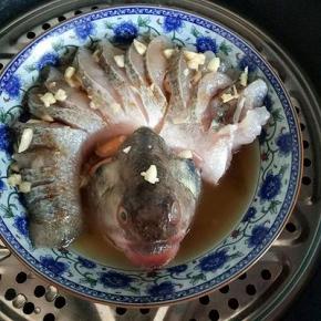 把切好的蒜撒在鱼身上，隔水蒸12-15分钟，关火焖3分钟。