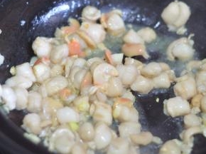 扇贝肉倒掉水分，倒入锅里翻炒。