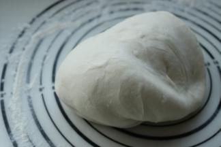 发酵好的面团移到揉面垫上，再次揉光滑，排出面团的气体。