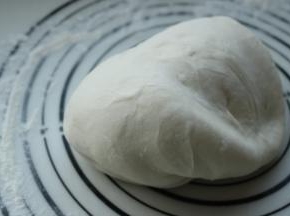 发酵好的面团移到揉面垫上，再次揉光滑，排出面团的气体。