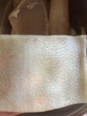 捞出来再把猪皮上面的油脂用刀刮掉，一定要刮干净。所以刮刮刮，使劲儿刮刮刮，还得再仔细找一下表皮的毛，要不然吃的时候看见了会。。。（自己想）