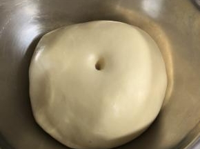 面团发酵至原来的2-2.5倍大，用手指沾点高筋面粉，在面团中戳一个洞，洞口稍微有一些回缩证明已经发酵完成。