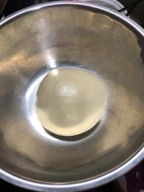 将所有主料放入厨师机搅拌，揉至面团可以拉出薄膜。尽量把膜揉的好一点，膜揉的越好，做出来的面包会越软，组织越细腻。揉好的面团如果有点粘手，可以手上抹一点植物油，然后把面团滚圆，放入一干净容器，盖上保鲜膜，我在烤箱放入一碗热水，放入面团进行发酵。