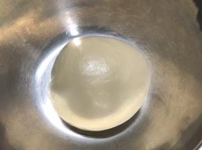 将所有主料放入厨师机搅拌，揉至面团可以拉出薄膜。尽量把膜揉的好一点，膜揉的越好，做出来的面包会越软，组织越细腻。揉好的面团如果有点粘手，可以手上抹一点植物油，然后把面团滚圆，放入一干净容器，盖上保鲜膜，我在烤箱放入一碗热水，放入面团进行发酵。