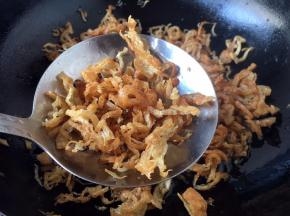 用笊篱盛起面筋丝，轻轻颠勺时，发出沙沙的声音时，捞出面筋丝。
