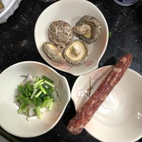 冬菇泡发，泡发好后切片，加入少许糖、麻油、蚝油腌制一会。腊肠切片，备用。