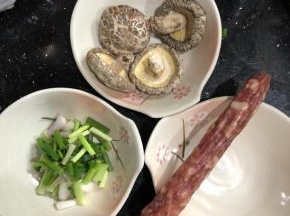 冬菇泡发，泡发好后切片，加入少许糖、麻油、蚝油腌制一会。腊肠切片，备用。