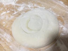 再从一边卷起，卷成一个圆，最后的尾部放在下边压好。