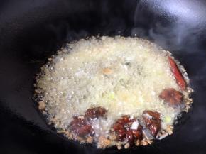 当八角煸出香味时依次放入姜米、蒜片葱花、辣椒爆香。