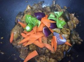 看锅中的汤汁让鸡肉快吸收，剩下不多时，下入青椒、胡萝卜和洋葱翻炒几下
