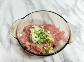 葱姜蒜去皮切碎。将切好的肉糜放入器具中，加入切好的葱姜蒜。