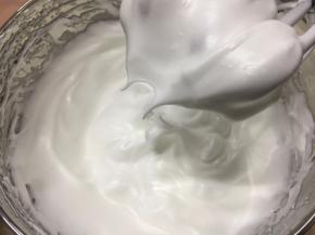 蛋清中分三次加入细砂糖，打发至9分，出现小弯钩，接近干性