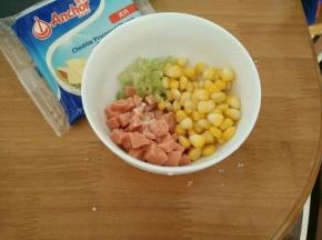 玉米提前煮熟，火腿肠和芹菜也切成小丁。然后加入适量胡椒粉，搅拌均匀。