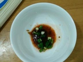 准备一个碗，放入酱油、辣椒酱和葱花。