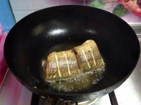 
锅内加油烧热至五成，分次下入鱼段煎至表面金黄捞出备用