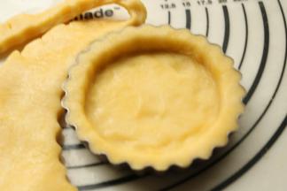 擀好的面皮揭去保鲜膜，附在模具上面，贴合模具擀去多余的部分。