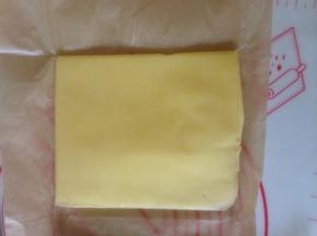 面团发酵的时候  把片状黄油用油纸包好  压成均匀的薄片